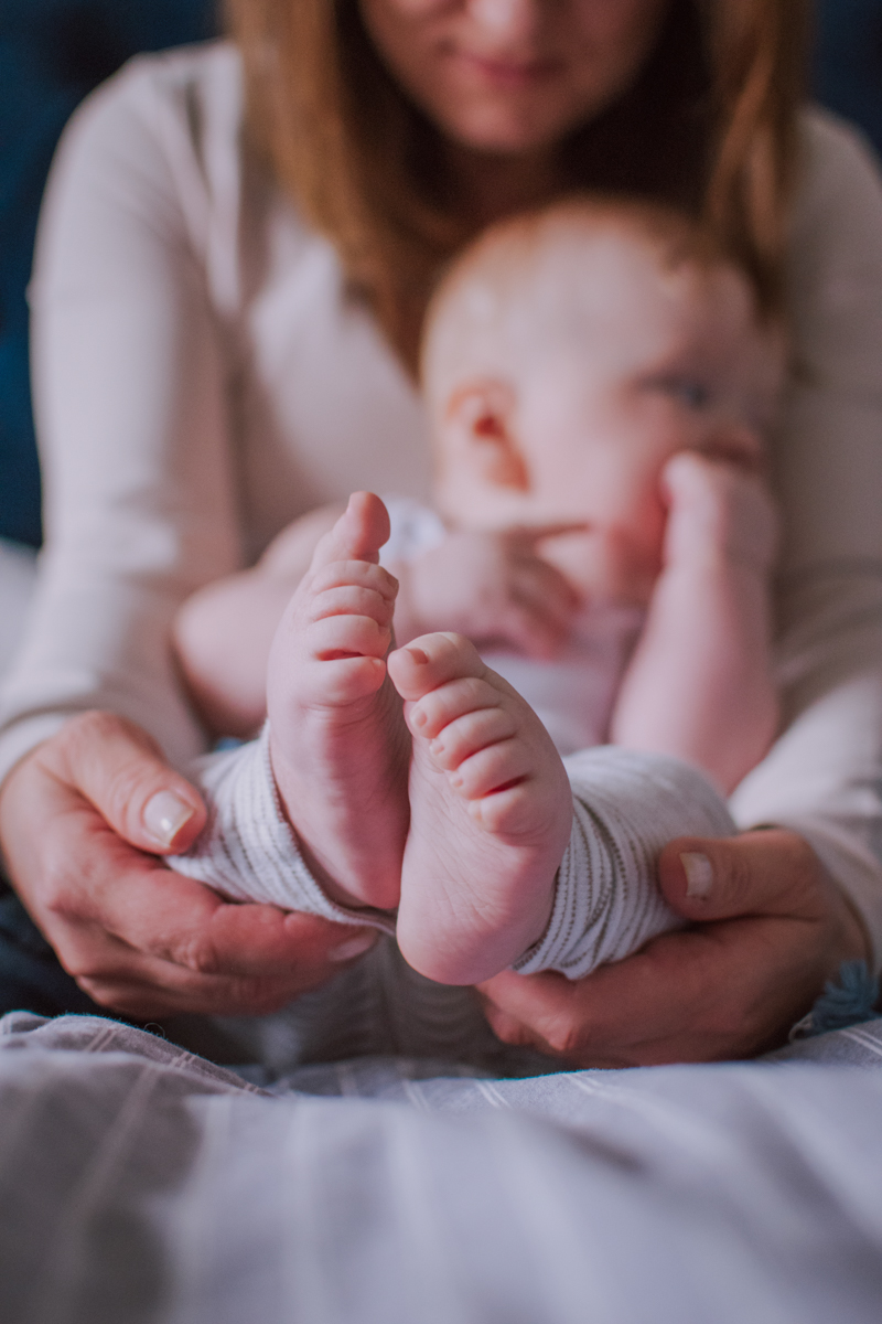 A close-up of a parent gently holding their baby's feet, capturing a tender moment of connection and affection.